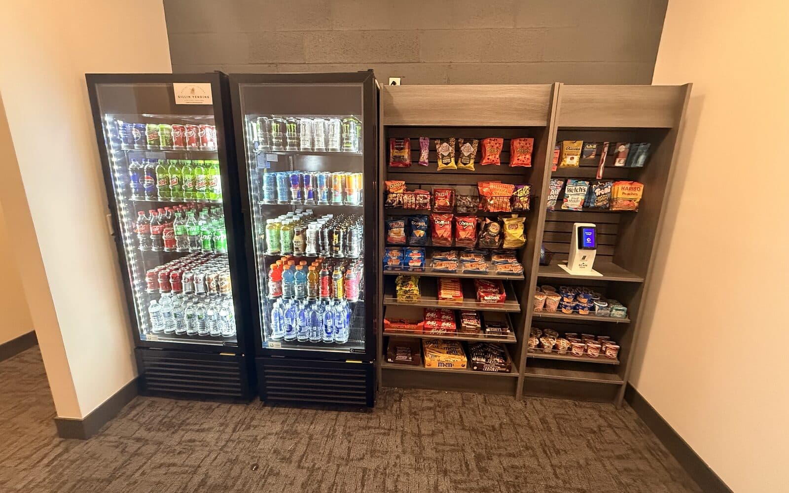 Two smart coolers and snack shelving in an apartment building amenity room