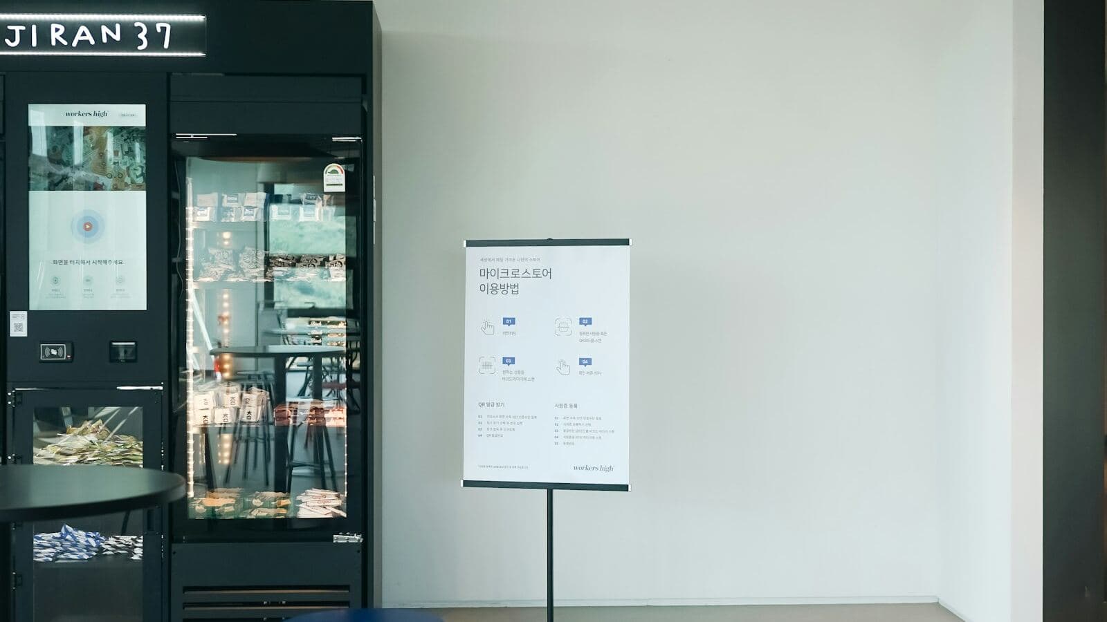 Refrigerated glass display case stocked with grab-and-go food in a modern office common area